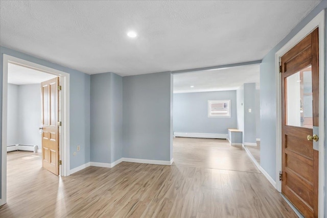 10 Lafountain St, Winooski, VT 05404 - entryway with a baseboard heating unit, light wood finished floors, a textured ceiling, a baseboard radiator, and recessed lighting