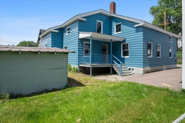 10 Lafountain St, Winooski, VT 05404 - rear view of house with a porch, a chimney, and a yard