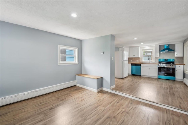 10 Lafountain St, Winooski, VT 05404 - unfurnished living room featuring a baseboard heating unit, light wood-style floors, recessed lighting, and a textured ceiling