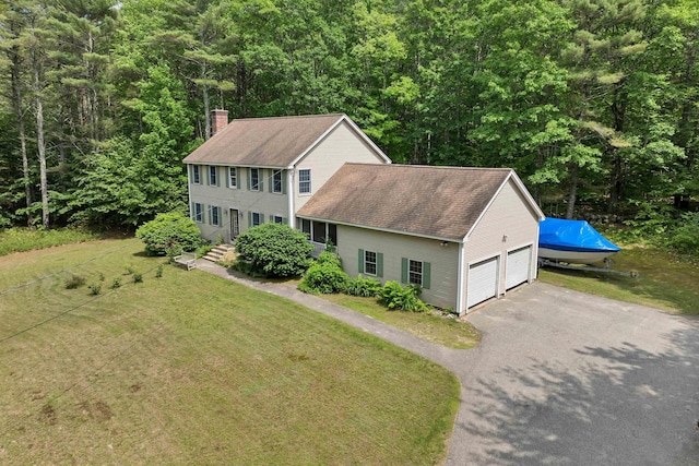 4 June Bug Ln, Wolfeboro, NH 03894 - view of front of home with a chimney, a shingled roof, a front yard, and a view of trees