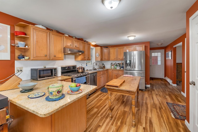 4 June Bug Ln, Wolfeboro, NH 03894 - kitchen featuring stainless steel appliances, under cabinet range hood, light wood-style flooring, a peninsula, and light stone countertops