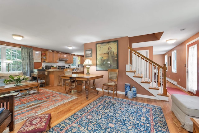 4 June Bug Ln, Wolfeboro, NH 03894 - living area with light wood-style floors, healthy amount of natural light, a baseboard radiator, and stairs