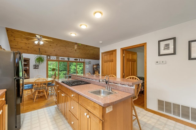 481 New Orchard Rd, Epsom, NH 03234 - kitchen with freestanding refrigerator, light flooring, a breakfast bar area, and ceiling fan