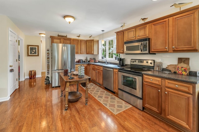 148 Deer Meadow Rd, Pittsfield, NH 03263 - kitchen with stainless steel appliances, dark countertops, wood finished floors, and brown cabinetry
