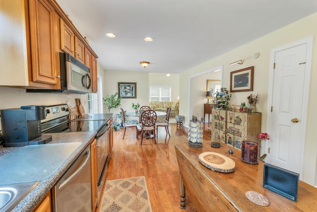 148 Deer Meadow Rd, Pittsfield, NH 03263 - kitchen with appliances with stainless steel finishes, brown cabinetry, light wood finished floors, and recessed lighting