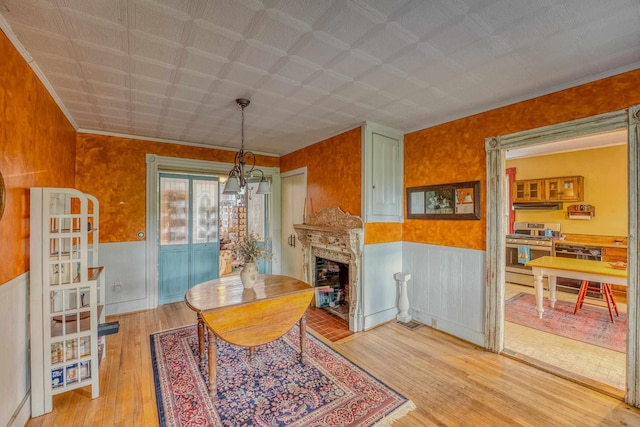 34 Union St, Littleton, NH 03561 - dining room featuring wood finished floors, a fireplace, wainscoting, and wood walls