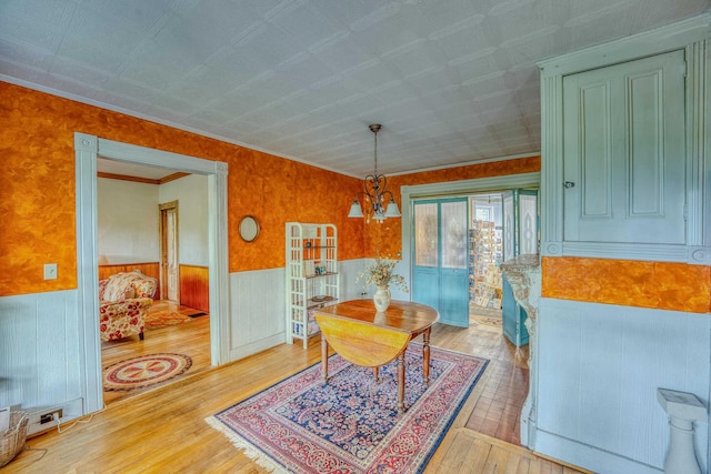 34 Union St, Littleton, NH 03561 - dining space with wood-type flooring, a wainscoted wall, a chandelier, and crown molding