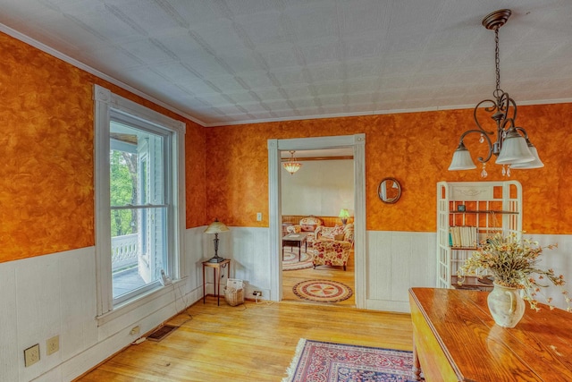 34 Union St, Littleton, NH 03561 - dining space with wood finished floors, a wainscoted wall, ornamental molding, and a chandelier