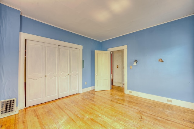 34 Union St, Littleton, NH 03561 - unfurnished bedroom featuring wood-type flooring, crown molding, and a closet