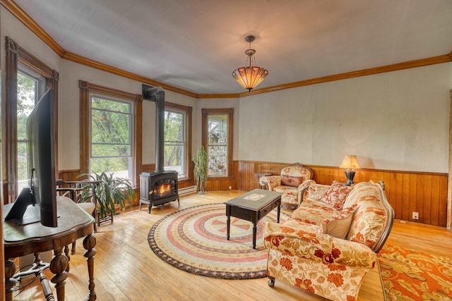 34 Union St, Littleton, NH 03561 - living area with a wood stove, wainscoting, hardwood / wood-style floors, wood walls, and ornamental molding