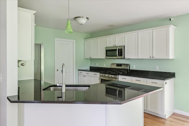 54 Gallagher Acres Ext, Moretown, VT 05676 - kitchen with appliances with stainless steel finishes, dark countertops, white cabinets, and light wood-style floors