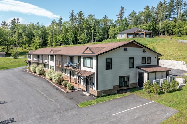 2366 Mountain Rd Unit 1, Stowe, VT 05672 - view of front of home with stone siding, a front lawn, and a shingled roof