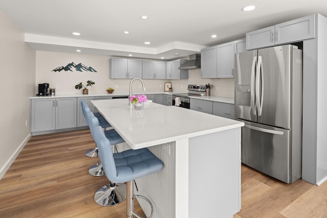 2366 Mountain Rd Unit 1, Stowe, VT 05672 - kitchen with appliances with stainless steel finishes, gray cabinetry, range hood, light wood finished floors, and recessed lighting