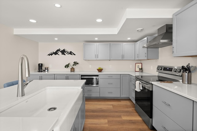 2366 Mountain Rd Unit 1, Stowe, VT 05672 - kitchen featuring stainless steel appliances, wall chimney range hood, gray cabinets, recessed lighting, and light countertops