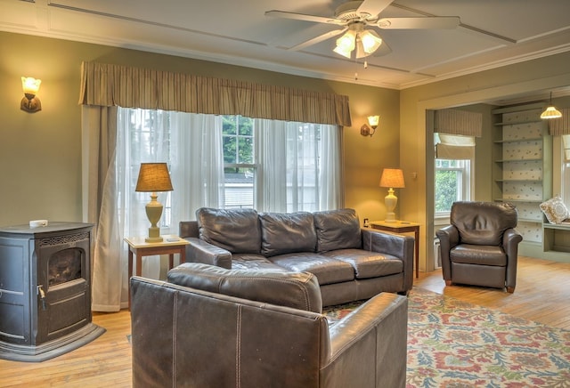 382 Park Ave, Keene, NH 03431 - living area featuring a wood stove, ornamental molding, healthy amount of natural light, a ceiling fan, and light wood-style floors
