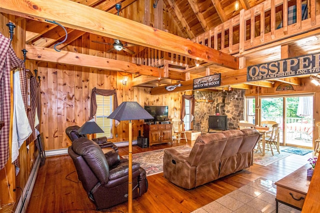 20 Pine Lane Rd, Ossipee, NH 03890 - living room with a wood stove, wood walls, wood ceiling, baseboard heating, and hardwood / wood-style floors