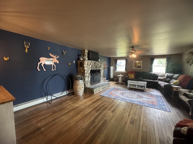 2940 Rte 30, Castleton, VT 05732 - living room featuring hardwood / wood-style flooring, a stone fireplace, ceiling fan, and baseboard heating