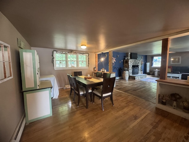2940 Rte 30, Castleton, VT 05732 - dining space with a stone fireplace, hardwood / wood-style flooring, and a baseboard radiator