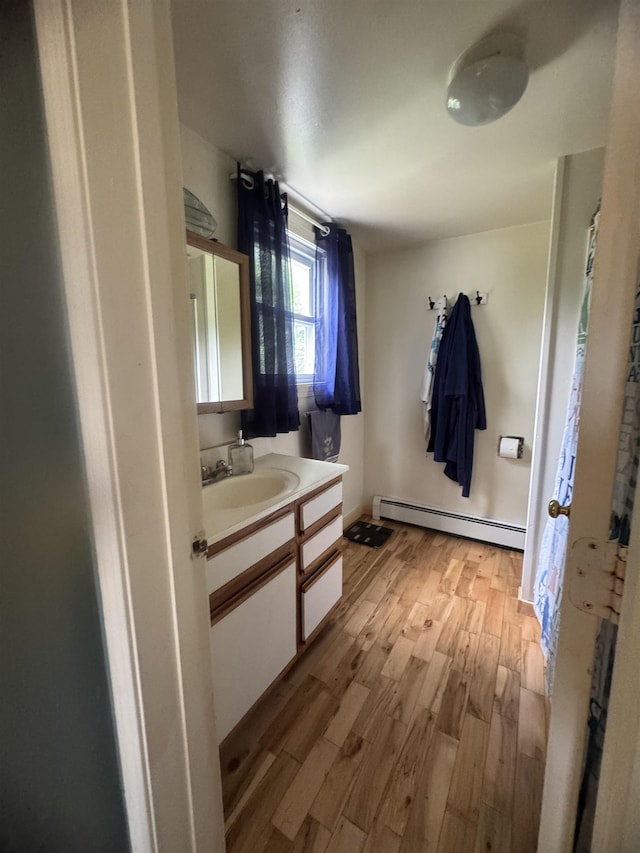 2940 Rte 30, Castleton, VT 05732 - bathroom with a baseboard heating unit, vanity, and wood finished floors