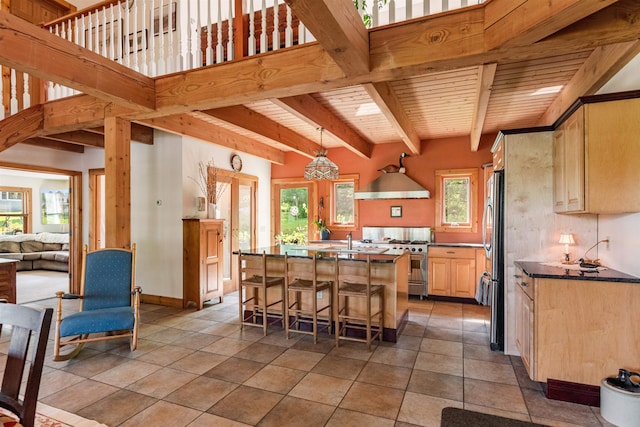532 Randolph Rd, Stowe, VT 05672 - kitchen featuring stainless steel appliances, a breakfast bar, light brown cabinets, a kitchen island, and dark countertops