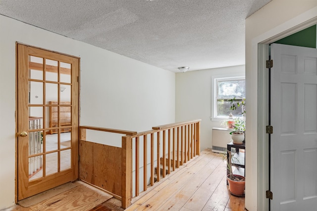 532 Randolph Rd, Stowe, VT 05672 - hallway with wood-type flooring, a textured ceiling, and an upstairs landing