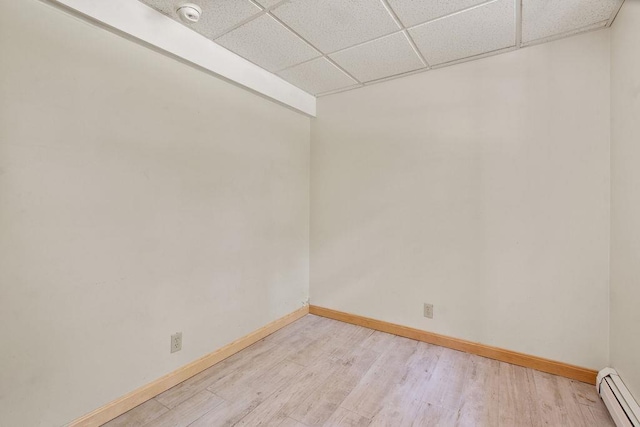 23 Riverlake St, Alton, NH 03810 - unfurnished room featuring baseboard heating, a smoke detector, a drop ceiling, and light wood-style flooring