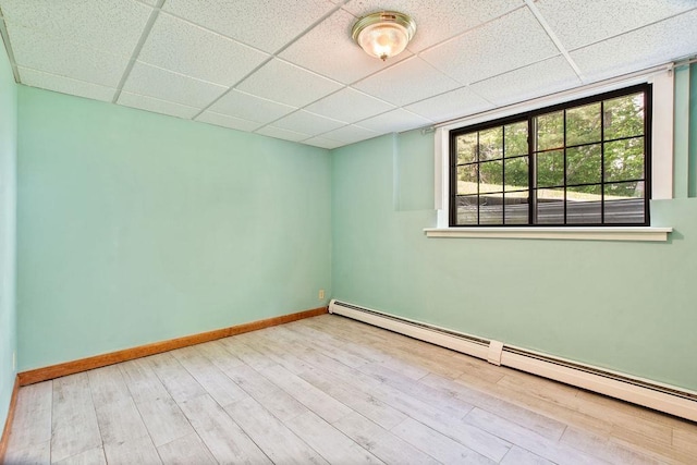 23 Riverlake St, Alton, NH 03810 - empty room featuring baseboard heating, a drop ceiling, and wood finished floors