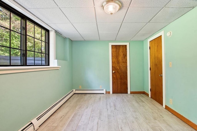 23 Riverlake St, Alton, NH 03810 - spare room featuring a baseboard radiator, a paneled ceiling, wood finished floors, and a smoke detector