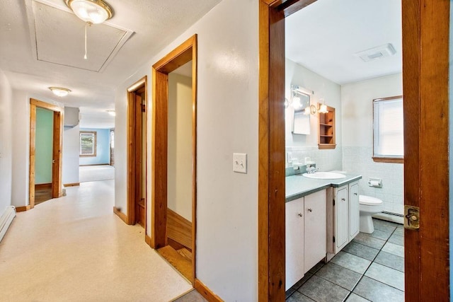 23 Riverlake St, Alton, NH 03810 - hall featuring attic access, a baseboard radiator, and tile walls