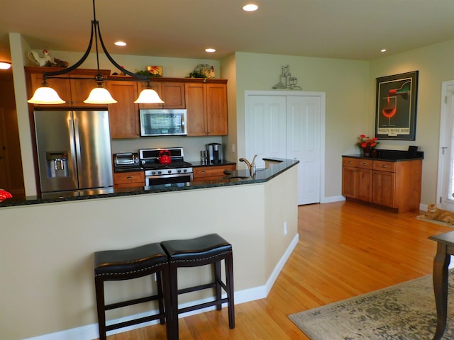 150 Pleasant Pond Way Unit 15, Manchester, NH 03102 - kitchen featuring appliances with stainless steel finishes, light wood-style floors, recessed lighting, decorative light fixtures, and brown cabinets