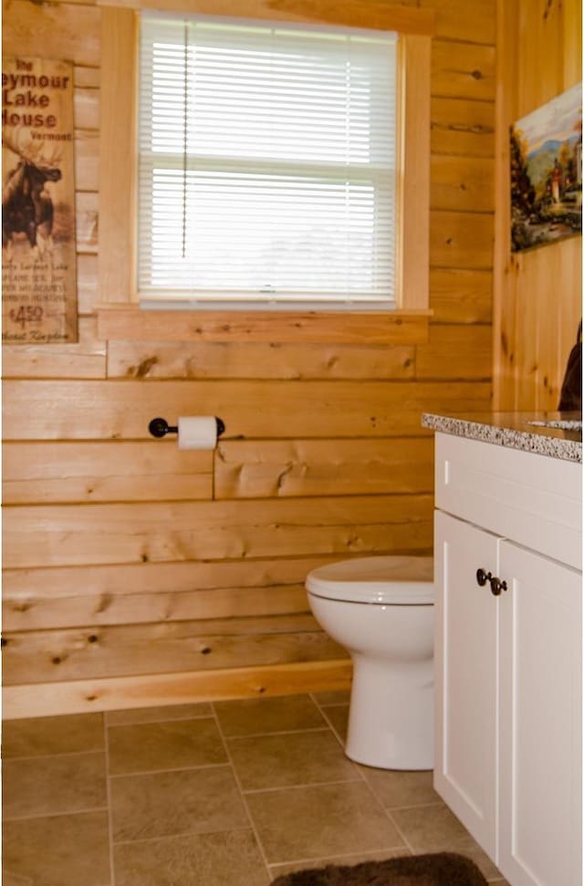 535 Mead Hill Rd, Holland, VT 05830 - bathroom featuring wooden walls, vanity, and tile patterned floors