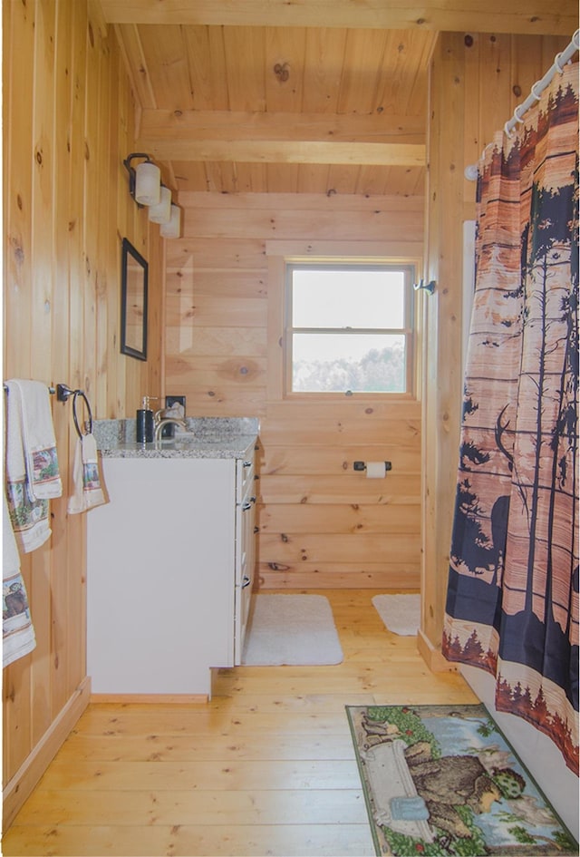535 Mead Hill Rd, Holland, VT 05830 - full bathroom with wood walls, a wooden ceiling with exposed beams, wood-type flooring, vanity, and a shower with curtain