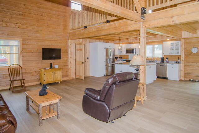 535 Mead Hill Rd, Holland, VT 05830 - living area featuring wood walls, a high ceiling, and light wood-style flooring