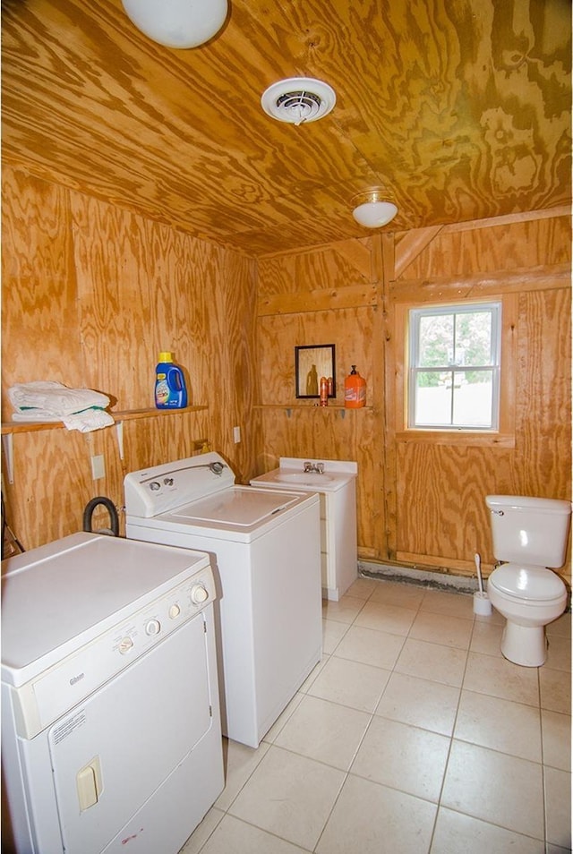 535 Mead Hill Rd, Holland, VT 05830 - laundry area with washer and clothes dryer, wood walls, and light tile patterned floors