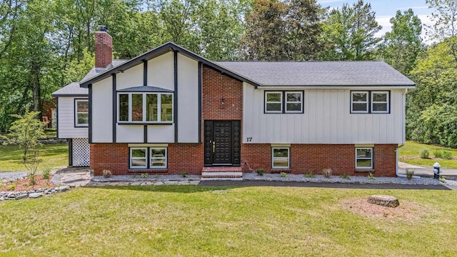 17 Brookview Dr, Pelham, NH 03076 - view of front of home featuring a front yard, brick siding, a chimney, and roof with shingles