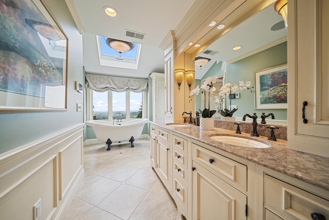 3 Baldwin Ln, Bedford, NH 03110 - bathroom with tile patterned floors, double vanity, a skylight, a freestanding tub, and recessed lighting