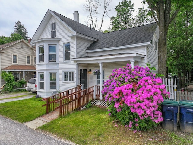 5 School St, Tilton, NH 03276 - view of front of house featuring covered porch, a front lawn, a shingled roof, and a chimney