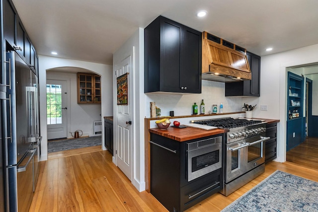 121 Main St, New Ipswich, NH 03071 - kitchen with high end appliances, dark cabinets, premium range hood, light wood-style flooring, and recessed lighting