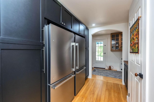 121 Main St, New Ipswich, NH 03071 - kitchen featuring light wood-type flooring, arched walkways, recessed lighting, dark cabinetry, and high end fridge