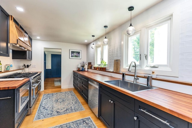 121 Main St, New Ipswich, NH 03071 - kitchen featuring butcher block countertops, stainless steel appliances, light wood-style floors, pendant lighting, and dark cabinets