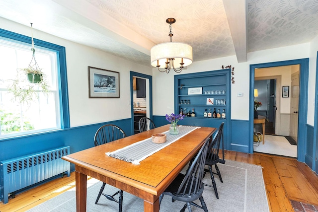 121 Main St, New Ipswich, NH 03071 - dining space featuring radiator heating unit, hardwood / wood-style flooring, a chandelier, a wainscoted wall, and beamed ceiling