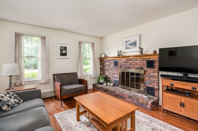 1 Constable Rd, Durham, NH 03824 - living room featuring baseboard heating, a brick fireplace, and light wood finished floors