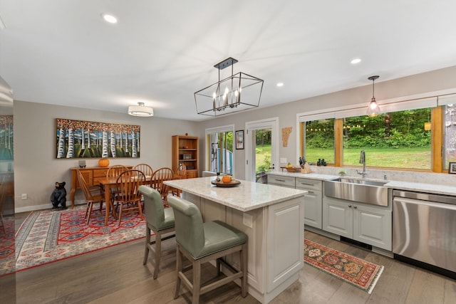 149 Club Sugarbush N Rd, Warren, VT 05674 - kitchen featuring stainless steel dishwasher, a kitchen island, wood finished floors, light stone counters, and decorative light fixtures