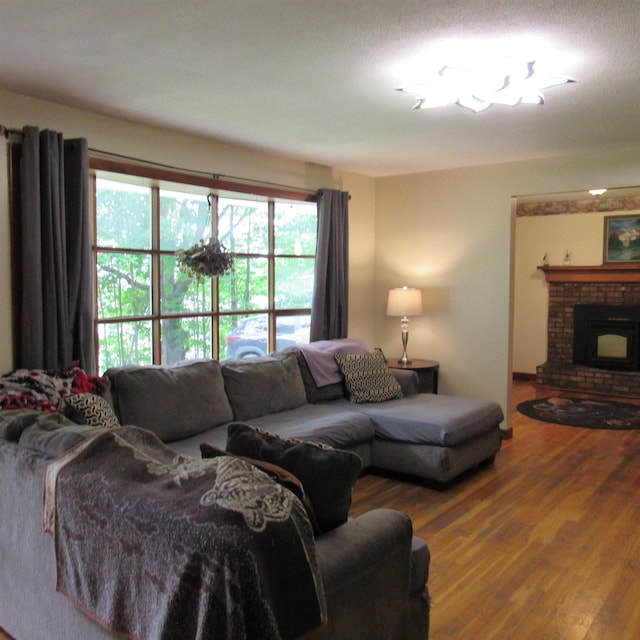129 Chestnut St, Claremont, NH 03743 - living area featuring wood finished floors and a brick fireplace