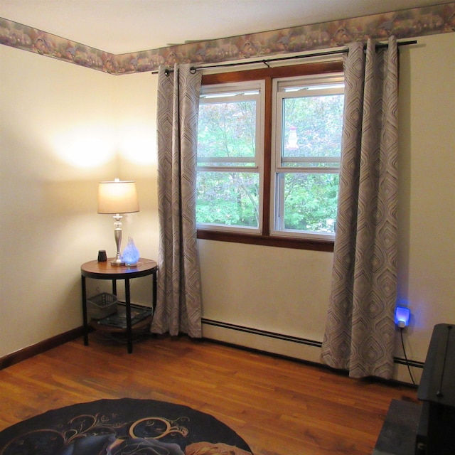 129 Chestnut St, Claremont, NH 03743 - living area featuring baseboard heating and wood finished floors