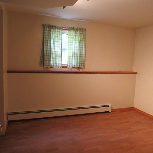 129 Chestnut St, Claremont, NH 03743 - unfurnished room featuring ceiling fan, wood finished floors, and a baseboard heating unit