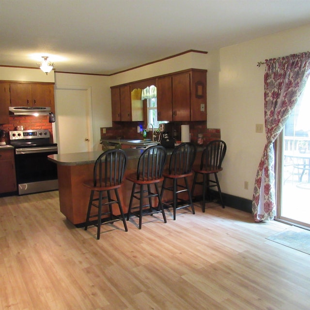 129 Chestnut St, Claremont, NH 03743 - kitchen featuring stainless steel electric stove, extractor fan, backsplash, a peninsula, and dark countertops