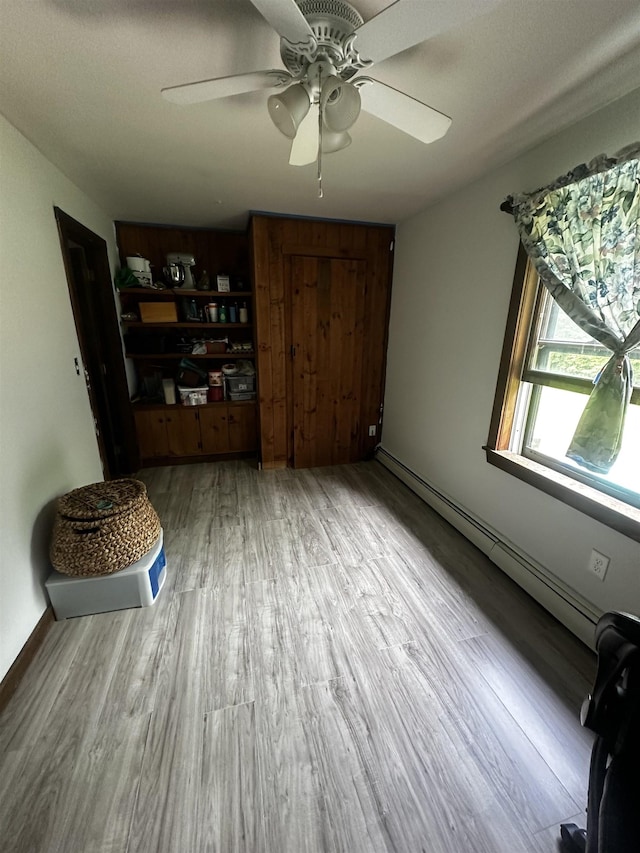 74 Dutton District Rd, Springfield, VT 05156 - unfurnished living room with a baseboard heating unit, a ceiling fan, and wood finished floors