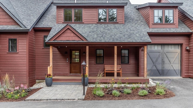 3148 Mountain Rd Unit B, Stowe, VT 05672 - view of front of property featuring a shingled roof, covered porch, driveway, and a garage
