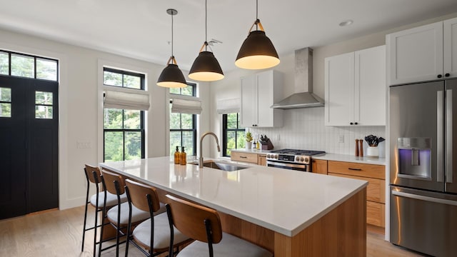 3148 Mountain Rd Unit B, Stowe, VT 05672 - kitchen with appliances with stainless steel finishes, wall chimney range hood, light wood-type flooring, tasteful backsplash, and recessed lighting